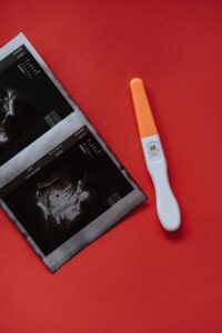 an ultrasound and a pregnancy test on a red surface