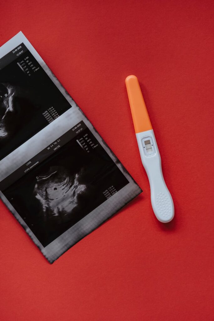 an ultrasound and a pregnancy test on a red surface